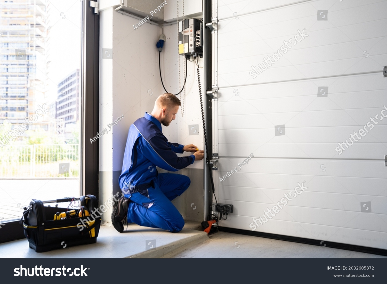 stock-photo-garage-door-installation-and-repair-at-home-contractor-man-in-house-2032605872