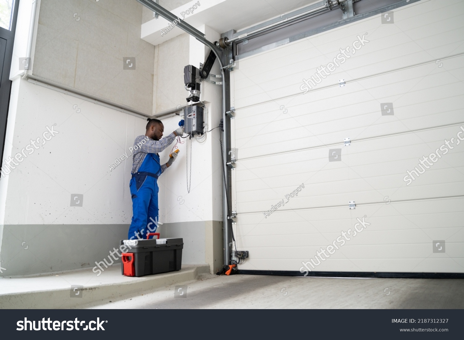 stock-photo-garage-door-installation-and-repair-at-home-contractor-man-in-house-2187312327